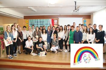 Liczna grupa uczniów na scenie, logo SOSW - tęcza