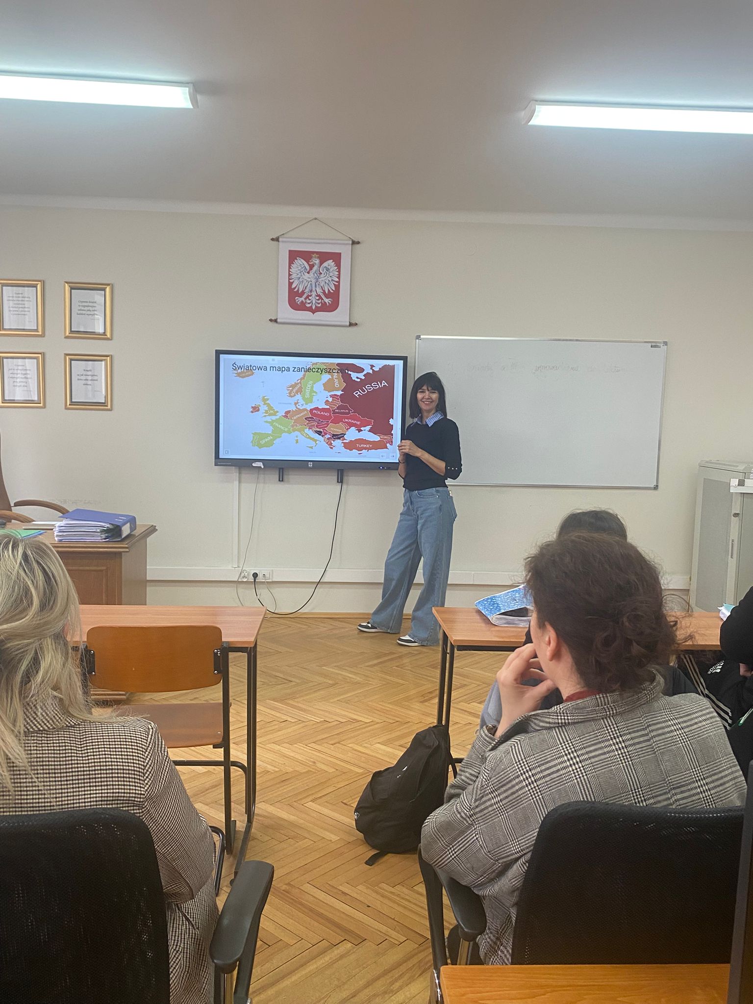 Nauczycielka prowadzi prelekcję, inni nauczyciele słuchają 