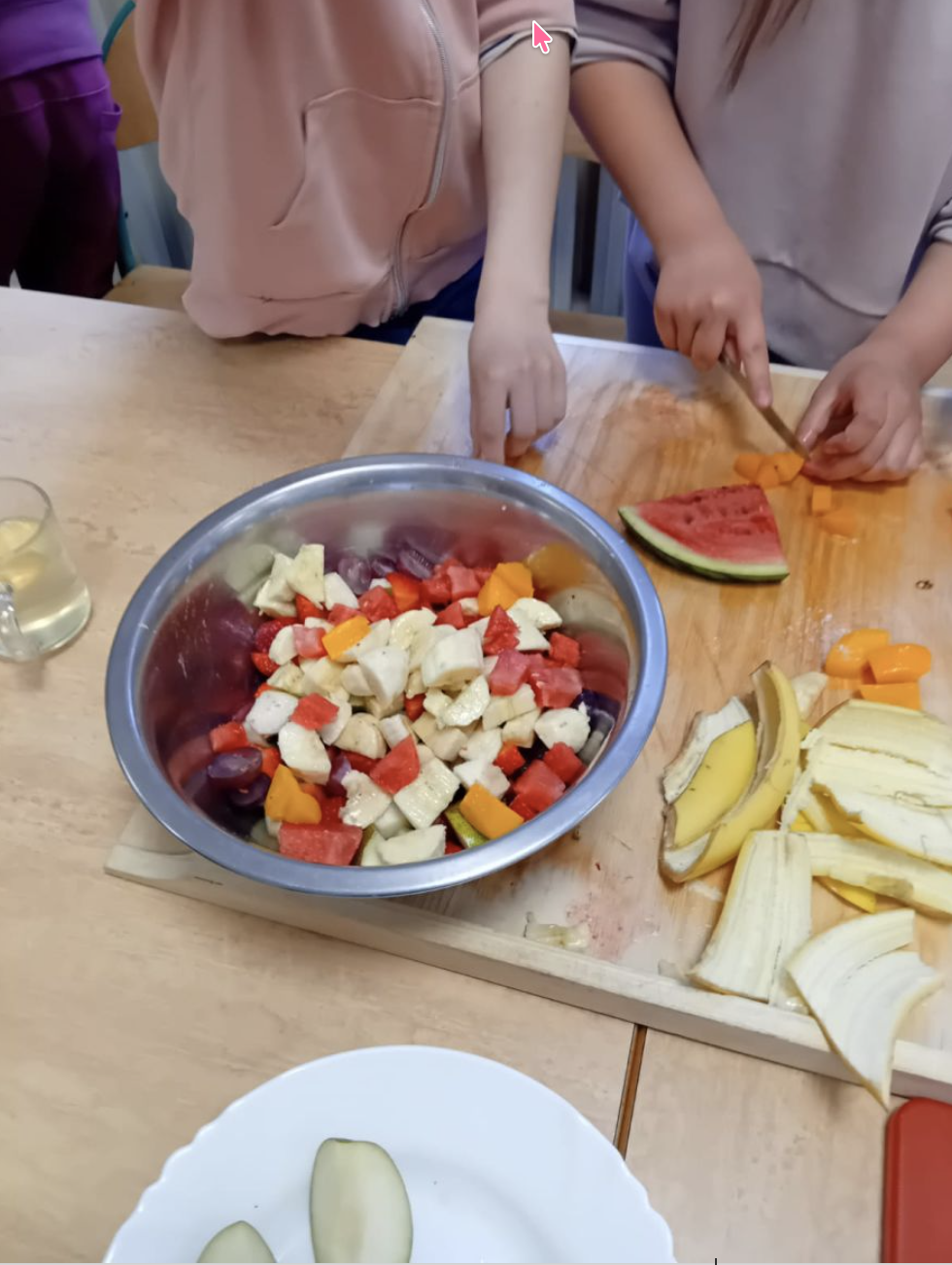 Uczennice kroją owoce do sałatki