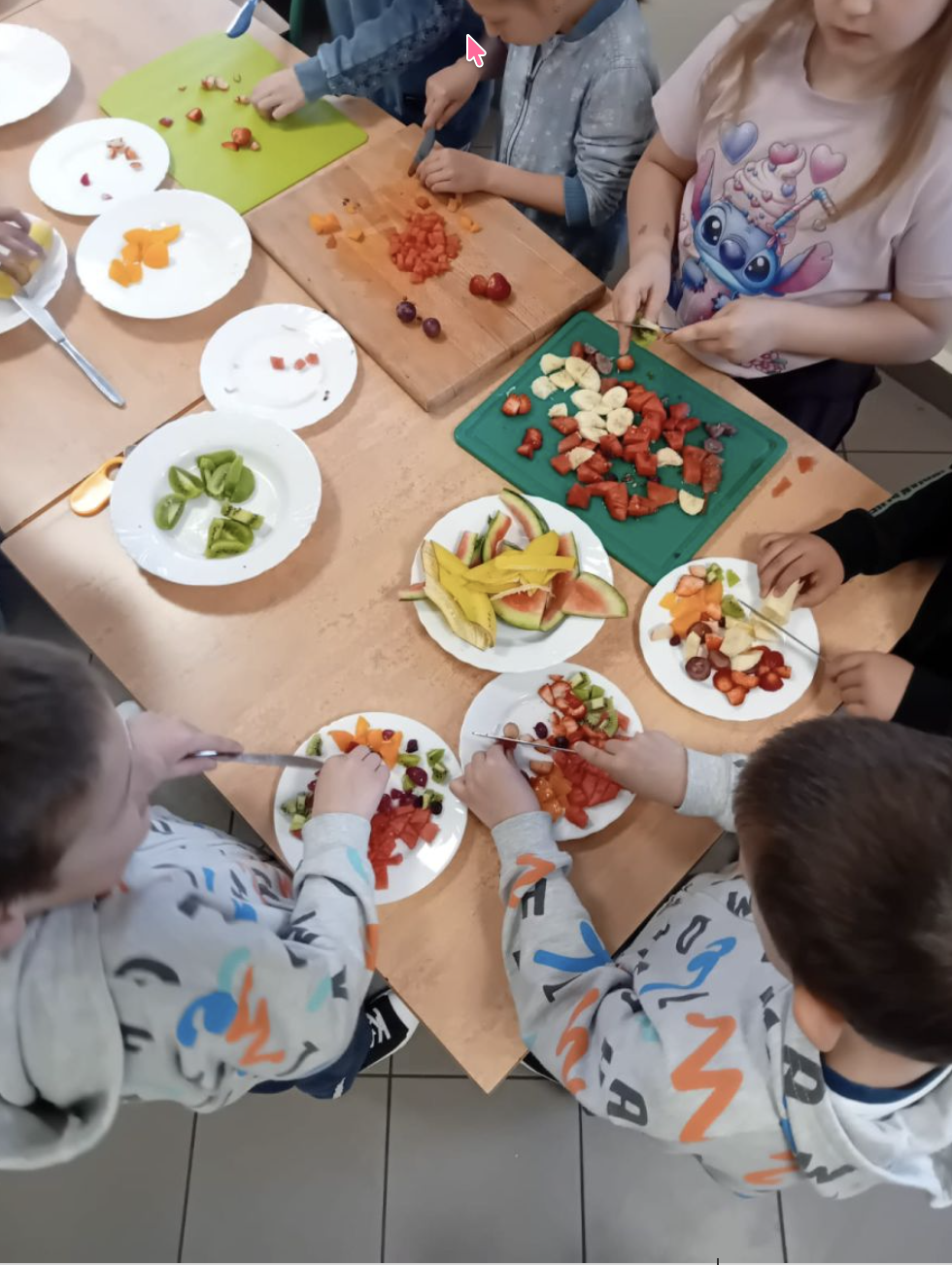 Uczniowie kroją owoce