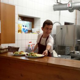 Uczeń za ladą podaje danie