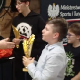 Wychowanek odbiera puchar w  klubie bilardowym.