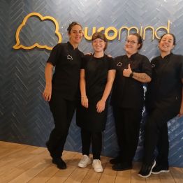 Uczniowie w czarnych strojach, za nim napis na ścianie: euromind