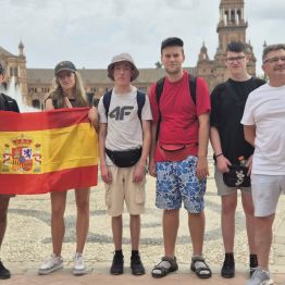 Uczniowie trzymają flagę Hiszpanii 