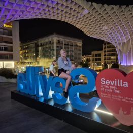 Uczennica siedzi na niebieskim napisie Sevilla 