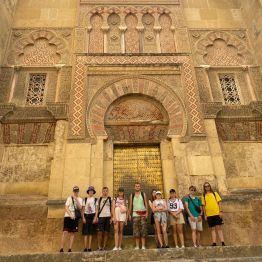 Uczniowie podczas zwiedzania Hiszpanii, w tle zabytkowy budynek 