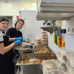 Uczennice w kuchni pakują jedzenie do pojemników 