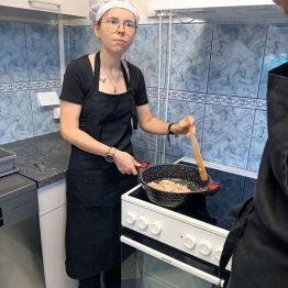 Uczennica smaży mięso na patelni