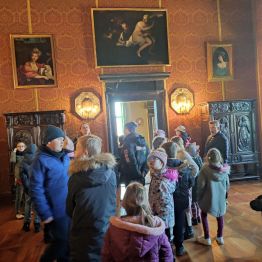 Grupa uczniów stojąca w jednym z pomieszczeń Muzeum Narodowego w Kielcach.