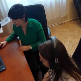 Dziewczynka w trakcie badania słuchu, obok prowądzaca badanie. 