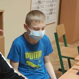 chłopiec obserwuje balansującego ptaka zaczepionego dziobem na piramidzie