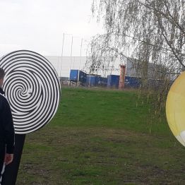 uczeń stoi przed jednym z urządzeń ze strefy optyki i kręci kołem