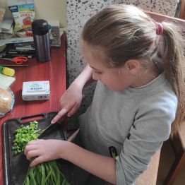 Daria kroi szczypiorek pod nadzorem wychowawczyni