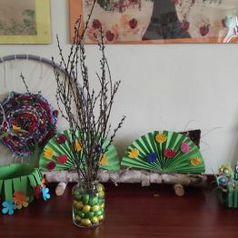 Fotografia przedstawiająca bazie w wazonie z czekoladowymi jajkami.