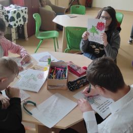 Grupa uczniów przygotowujących laurki rodzicom.