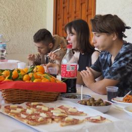 Grupa młodzieży przy stole podczas poczęstunku w Centro Diurno Avofid