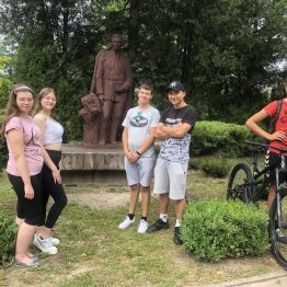 Uczniowie stoją pod pomnikiem Stefana Żeromskiego obok I LO w Kielcach.