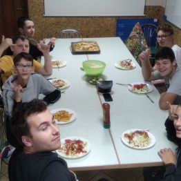 Grupa młodzieży pracująca w kuchni przy stole