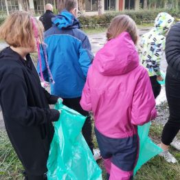 Dzieci z workami zbierają i segregują  śmieci.