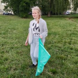 Druga dziewczynka zbiera śmieci.