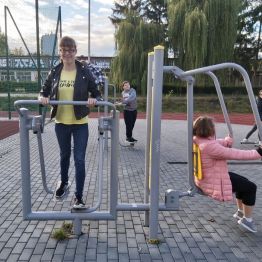 Dzieci ćwiczą na siłowni plenerowej.