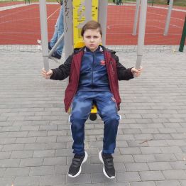 Chłopiec ćwiczy - wyciskanie siedząc.