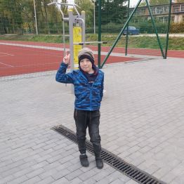 Chłopiec koło  siłowni plenerowej.