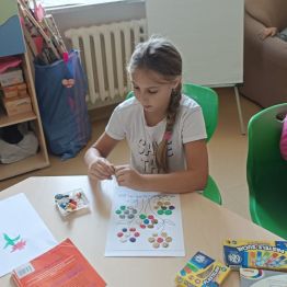 Daria przygotowuje kwiaty z plastelinowych kropek.
