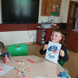 Miłosz w trakcie pracy plastycznej. Gabryś prezentuje swoją twórczość plastyczną z kropki.