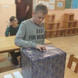 Chłopiec wrzuca głos do urny.