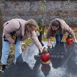 Dziewczynki sprzątają grób.