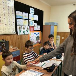 Uczennica wręcza słodycze dziecku.