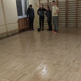Chłopcy stoją przy drabinkach na sali gimnastycznej