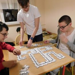 wychowankowie układają puzzle z kodami