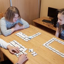 dziewczynki obserwują jak ozobot zczytuje kody 