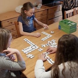 wychowankowie układaja puzzle z kodami
