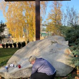 uczennica zapala znicz przy grobie