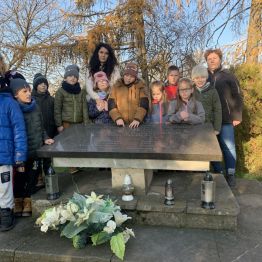 Uczniowie klas I a, I c i I e stojący przy pomniku ofiar okupacji. 