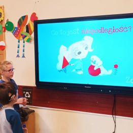 Uczniowie oglądają film edukacyjny o niepodległości.