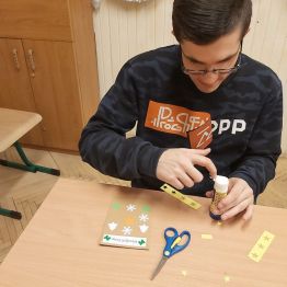 Hubert okleja wzorki świąteczne na kartce.