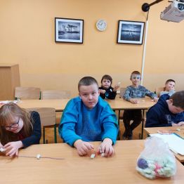 Dzieci z klas 1-3 SP podczas wykonywania wspólnego łańcucha świątecznego.