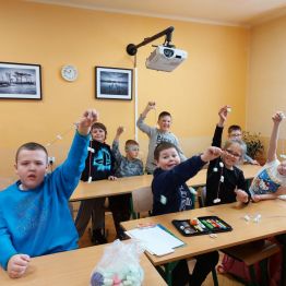 Dzieci z klas 1-3 SP podczas wykonywania wspólnego łańcucha świątecznego.
