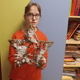 Natalia prezentuje gwiazdę betlejemską - zawieszkę z patyków.