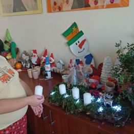 Sebastian przygotowuje świąteczny stroik na korze drewna.