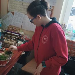 Krzyś przygotowuje stroiki świąteczne w kubkach.
