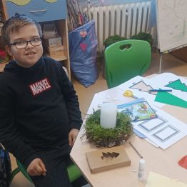 Kacper przygotowuje stroik bożonarodzeniowy.