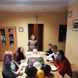 Dziewczyny siedzą przy stole i jedzą pizze