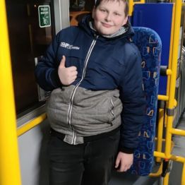 Chłopiec stoi w autobusie.