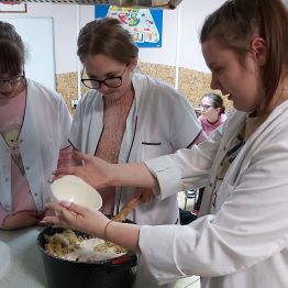 Dziewczynki dodają pozostałą część sosu do wszystkich składników.