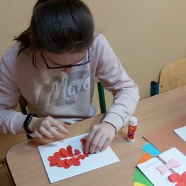 Dziewczynka wykleja na laurce.